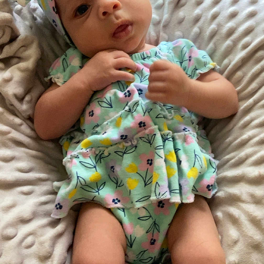 Kierra joined the competition — help win amazing prizes! baby, blanket, bow, child, clothing, comfortable, cute, expression, floral_pattern, hands, headband, indoors, infant, legs, lying_down, portrait, skin, socks, soft_texture, young_child