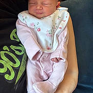 Layla is registered to the contest to win money with this photo: arm, baby, bib, closeup, cozy, cute, hand, human, indoors, infant, newborn, peaceful, person, pink_clothing, portrait, resting, sleeping, soft_fabric, toddler, young_child