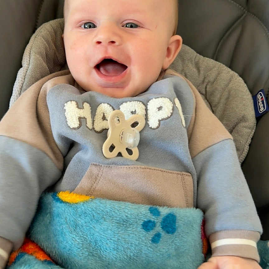 Mylane a rejoint le concours — aidez-le/la à gagner de superbes lots ! baby, blanket, blue_eyes, car_seat, cheeks, colorful_blanket, cozy, face, grinning, hand, hanging_toy, happy_text, hoodie, indoor, infant, pacifier, plush_toy, portrait, smiling, toy