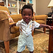 Theo joined the competition — help win amazing prizes! toddler, child, smiling, indoors, living_room, carpet, furniture, shirt, shorts, suspenders, barefoot, happy, home, person, cute, playful, portrait, young_child, carpeted_floor, standing