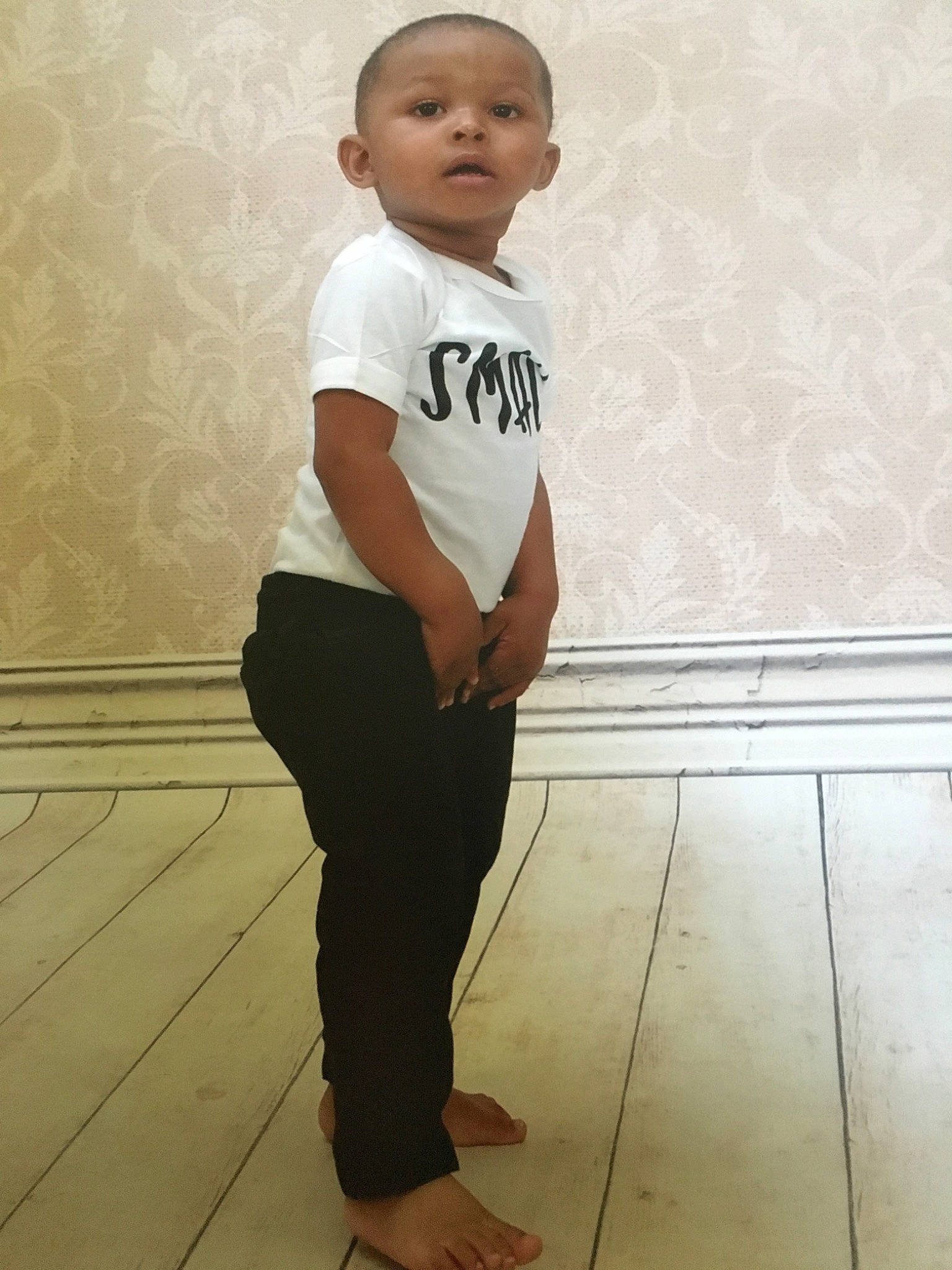 Uriah is registered to the contest to win money with this photo: child, floor, flooring, person, sleeve, standing, t_shirt, toddler