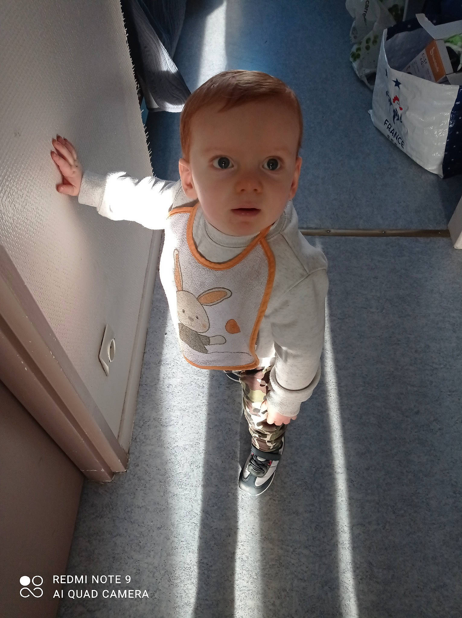 Corentin a rejoint le concours — aidez-le/la à gagner de superbes lots ! baby, baby_toddler_clothing, child, facial_expression, finger, flash_photography, floor, flooring, fun, gesture, happy, human_leg, joint, person, shoulder, sleeve, standing, t_shirt, thumb, toddler