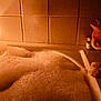 animal, bathroom, bubble_bath, candle, cat, cozy, curious, dim_lighting, feline, foam, glass, home, indoor, orange_cat, pet, red_drink, relaxation, still_life, tiles, warm_light