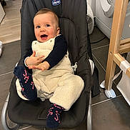 Léo a rejoint le concours — aidez-le/la à gagner de superbes lots ! baby, child, smiling, infant, baby_seat, fleece_overalls, socks, candy_cane_pattern, indoor, flooring, laundry_machine, home, baby_clothing, happy, playful, person, face, hand, seat, toy