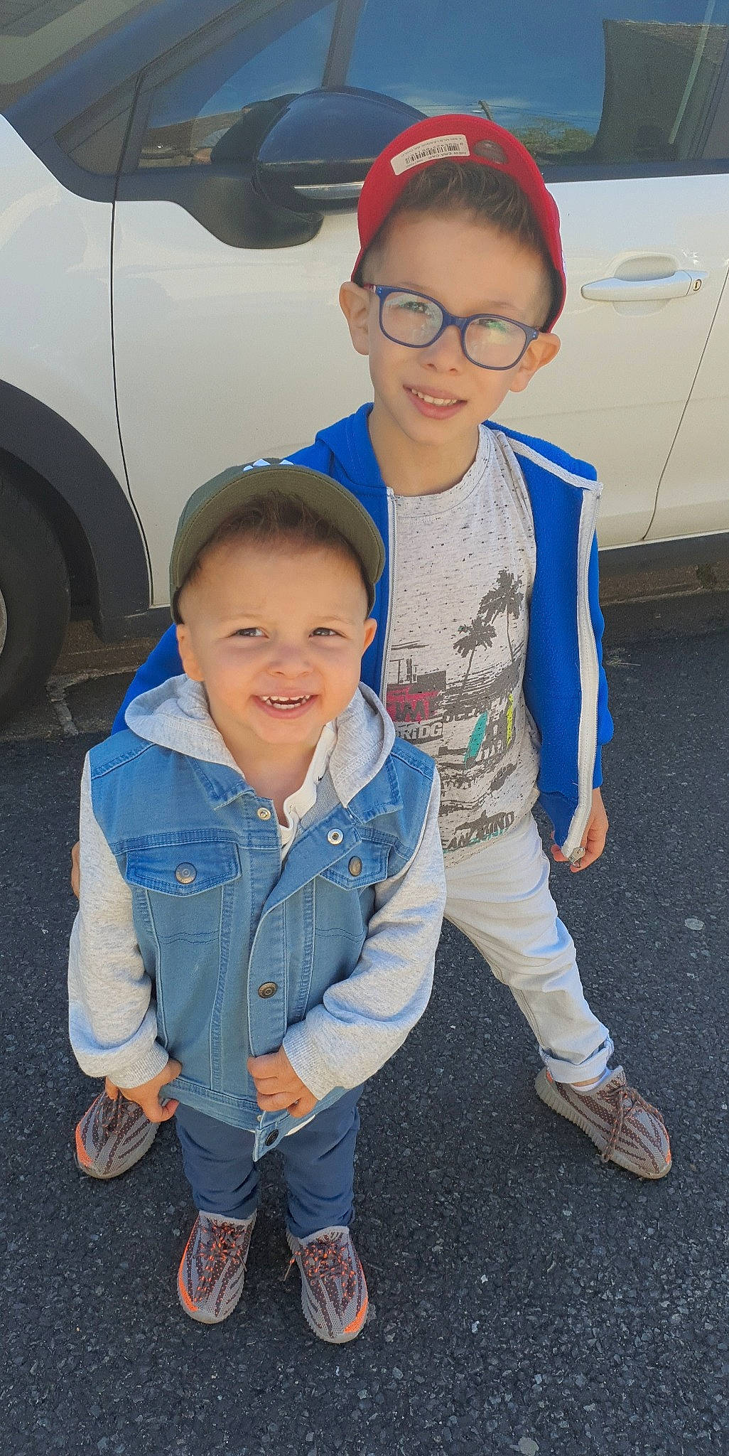 Lenzo participe au concours pour gagner de l'argent avec cette photo : automotive_design, eye, face, facial_expression, glasses, hairstyle, happy, head, joy, outerwear, person, product, shoe, skin, smile, sneakers, standing, tire, toddler, vision_care