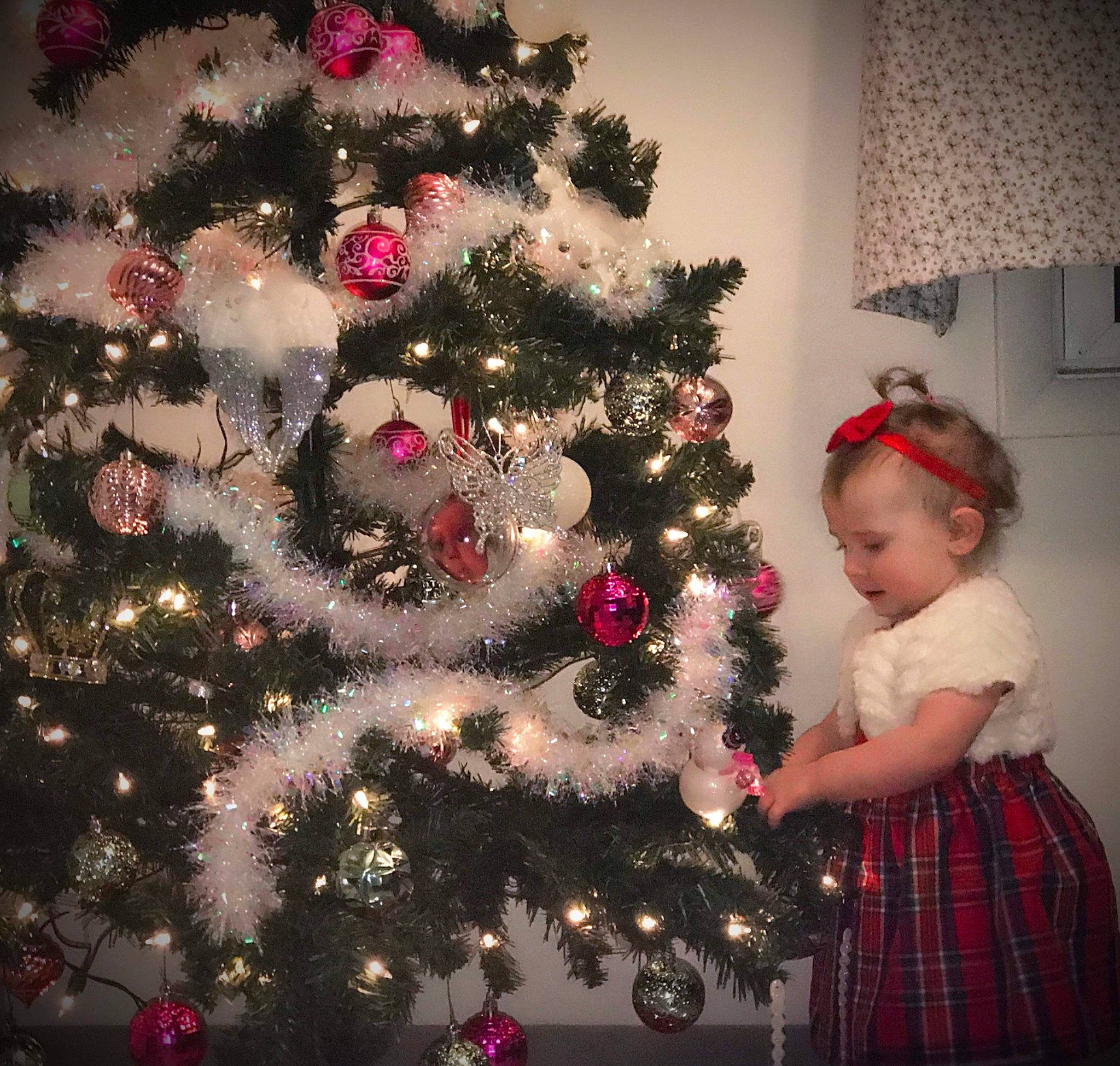 Reighna joined the competition — help win amazing prizes! beauty, christmas_decoration, christmas_ornament, christmas_tree, event, evergreen, holiday_ornament, human_body, light, lighting, ornament, person, plaid, plant, red, standing, tartan, toddler, tree, white