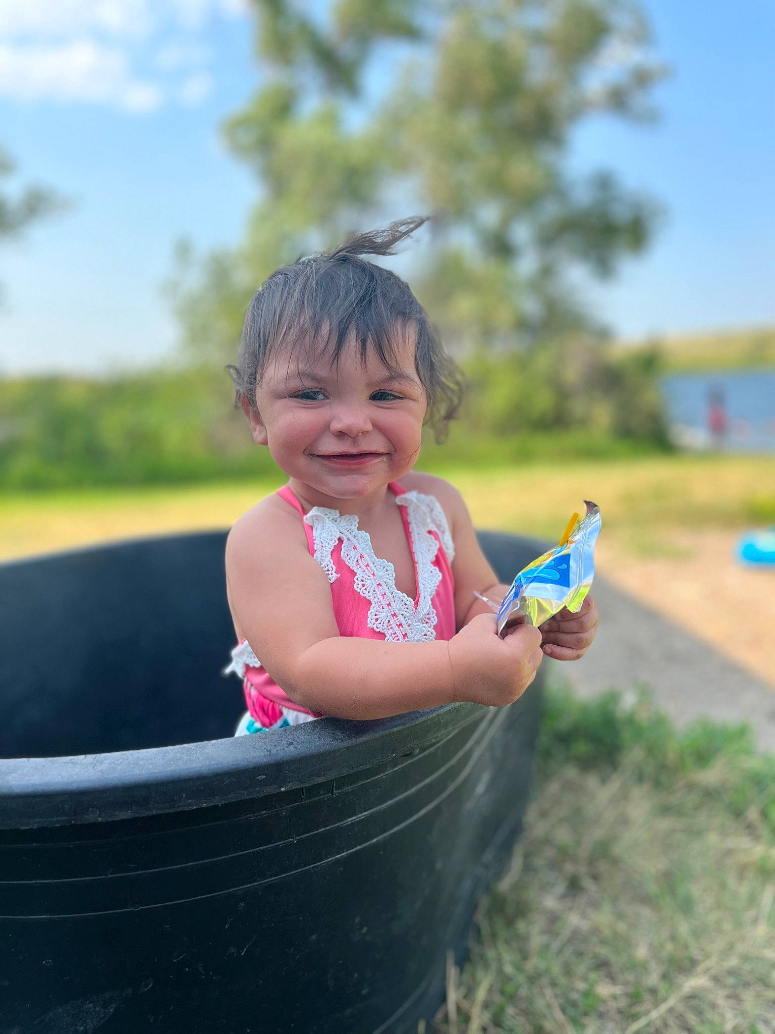 Madelyn is registered to the contest to win money with this photo: automotive_tire, baby_toddler_clothing, child, cloud, flash_photography, fun, grass, grass_family, happy, human_body, joy, leisure, people_in_nature, person, plant, recreation, sitting, sky, smile, toddler