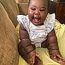 Brazil joined the competition — help win amazing prizes! baby, child, infant, smiling, laughing, portrait, sitting, indoor, couch, cushion, blanket, yellow_blanket, dress, ruffles, bare_feet, happy, face, closeup, living_room, photography