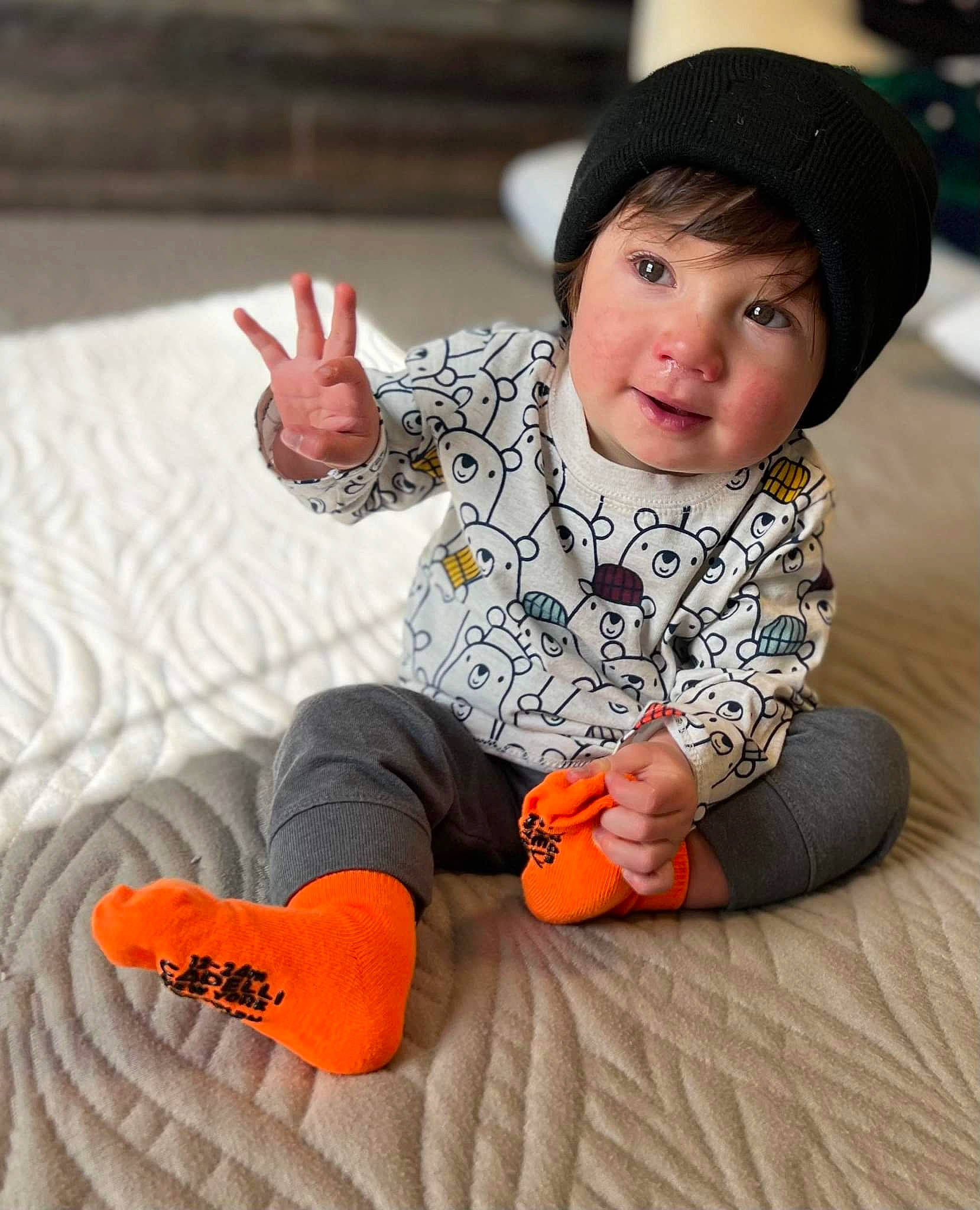 Vincent is registered to the contest to win money with this photo: arm, baby_toddler_clothing, cap, cheek, comfort, eye, face, finger, flash_photography, fun, gesture, happy, head, human_body, mammal, nose, orange, person, skin, sleeve