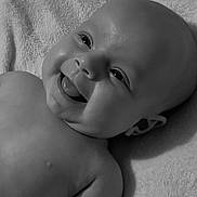 Lottie Mae is registered to the contest to win money with this photo: baby, infant, smiling, tongue_out, black_and_white, portrait, face, skin, head, eyes, mouth, lying_down, blanket, soft_texture, cute, happy, child, newborn, closeup, expression