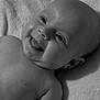 Lottie is registered to the contest to win money with this photo: baby, infant, smiling, tongue_out, black_and_white, portrait, face, skin, head, eyes, mouth, lying_down, blanket, soft_texture, cute, happy, child, newborn, closeup, expression