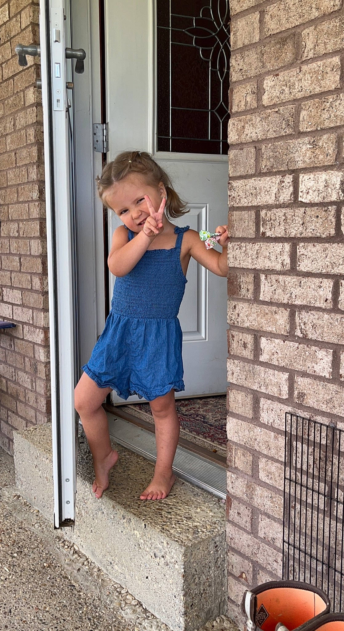 Emalee is registered to the contest to win money with this photo: brick, brickwork, clothing, day_dress, door, dress, electric_blue, flash_photography, flooring, fun, house, human_leg, person, plant, shoulder, stairs, standing, tree, waist, window