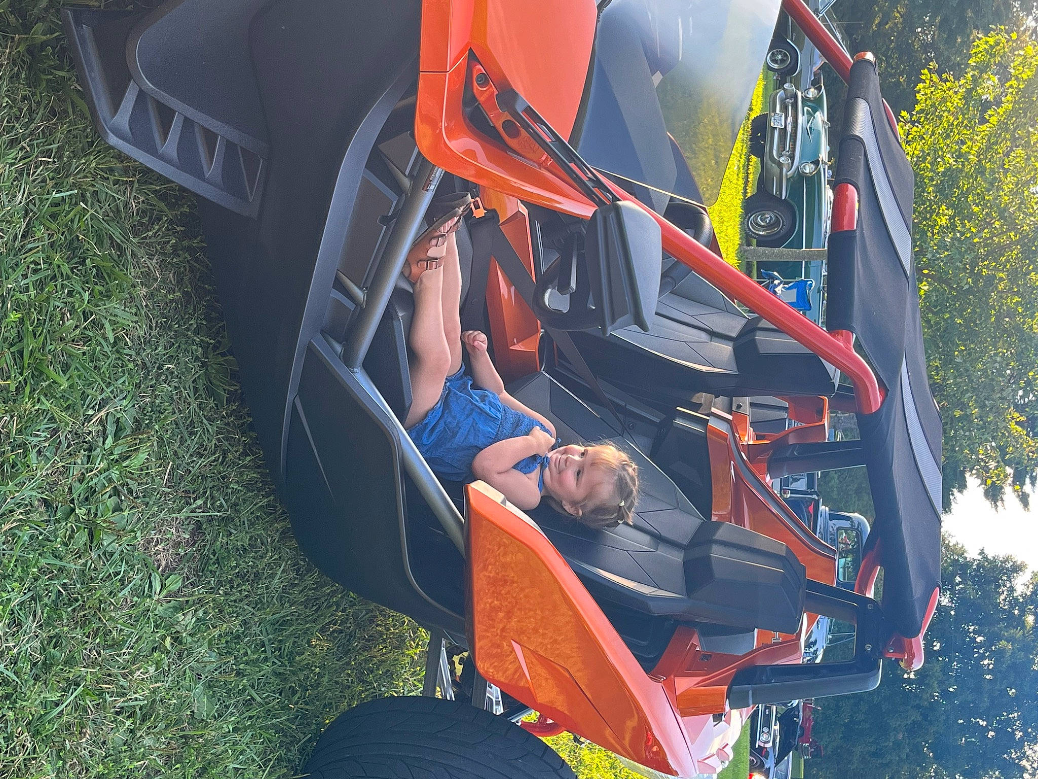 Emalee is registered to the contest to win money with this photo: auto_part, automotive_design, automotive_exterior, automotive_lighting, automotive_tire, automotive_wheel_system, bumper, car, grass, hood, leisure, motor_vehicle, person, plant, recreation, tire, tree, vehicle, vehicle_door, wheel