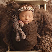 Savannah is registered to the contest to win money with this photo: newborn, baby, sleeping, wrapped, brown, blanket, crocheted_toy, teddy_bear, headband, flower, cute, peaceful, soft_texture, knit, wooden_cradle, portrait, infant, cozy, child, indoor