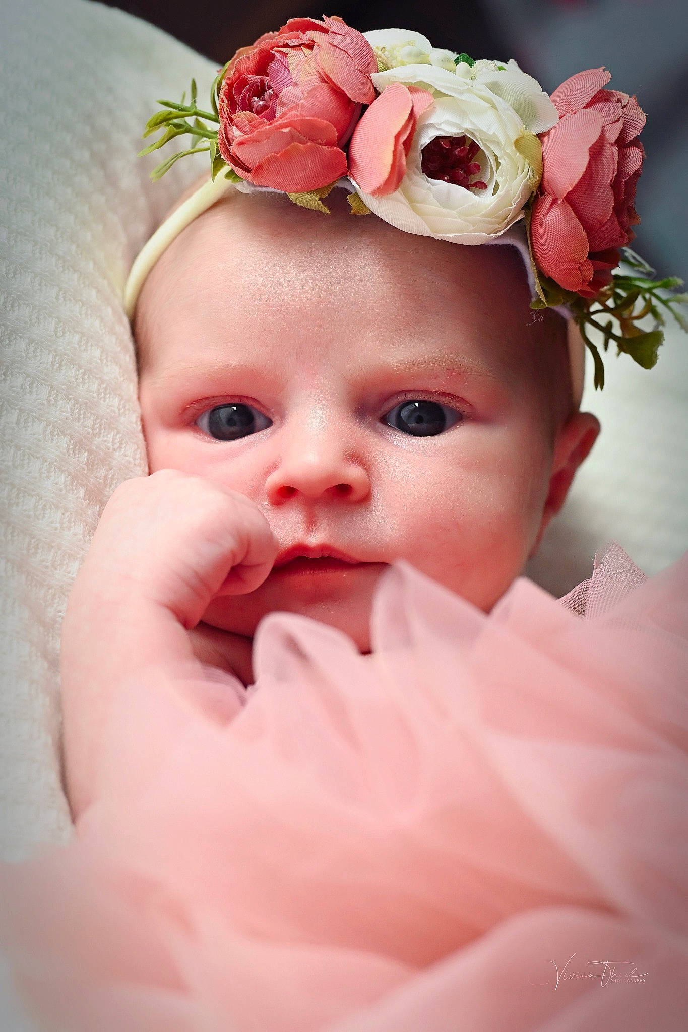 Calliope is registered to the contest to win money with this photo: baby, baby_toddler_clothing, cheek, eye, eyebrow, eyelash, face, finger, flash_photography, flower, happy, head, headgear, headpiece, iris, lip, person, petal, pink, skin