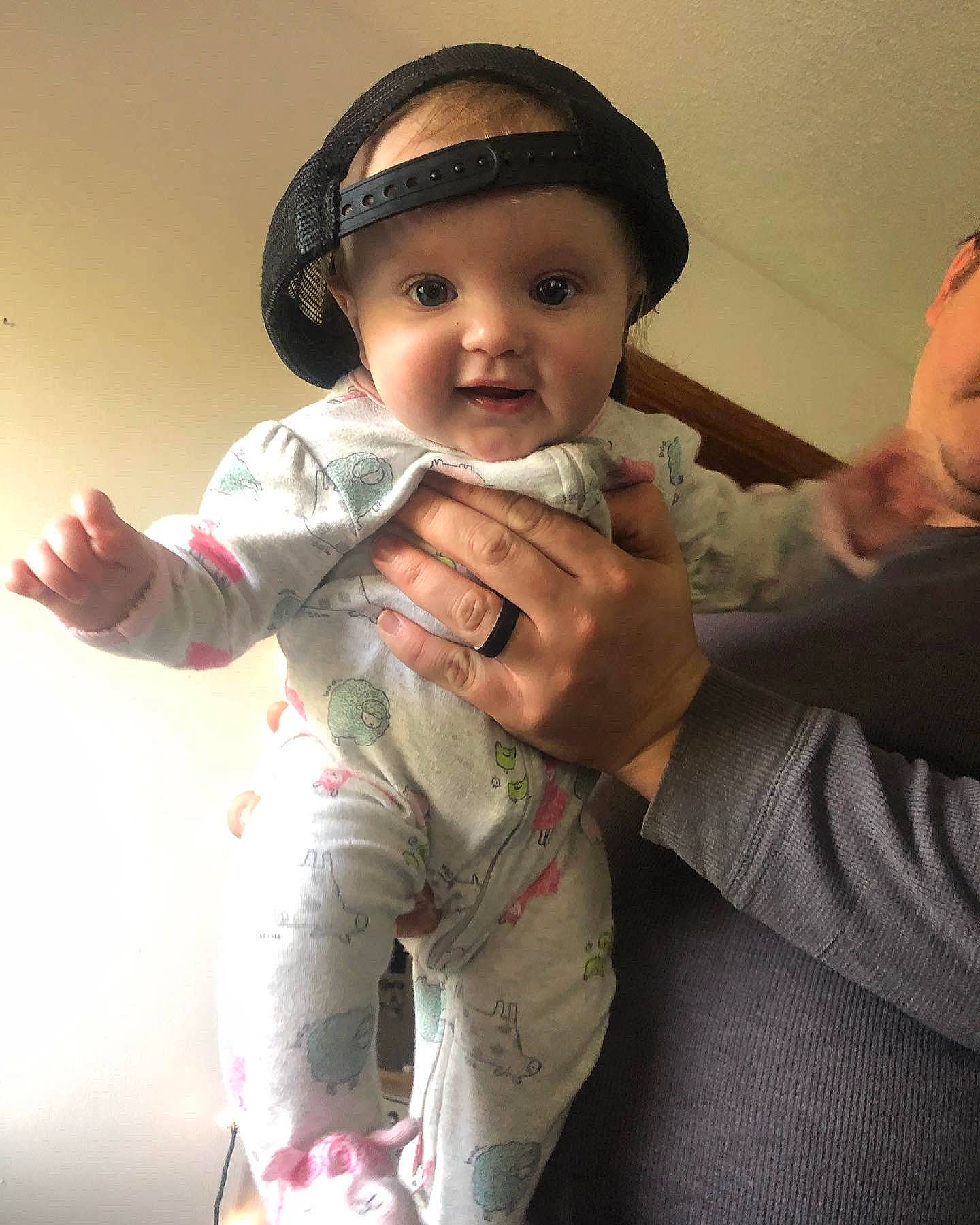 Elle is registered to the contest to win money with this photo: arm, baby_toddler_clothing, cap, cheek, eye, finger, flash_photography, gesture, happy, headgear, headwear, iris, lip, mouth, neck, nose, person, skin, sleeve, smile