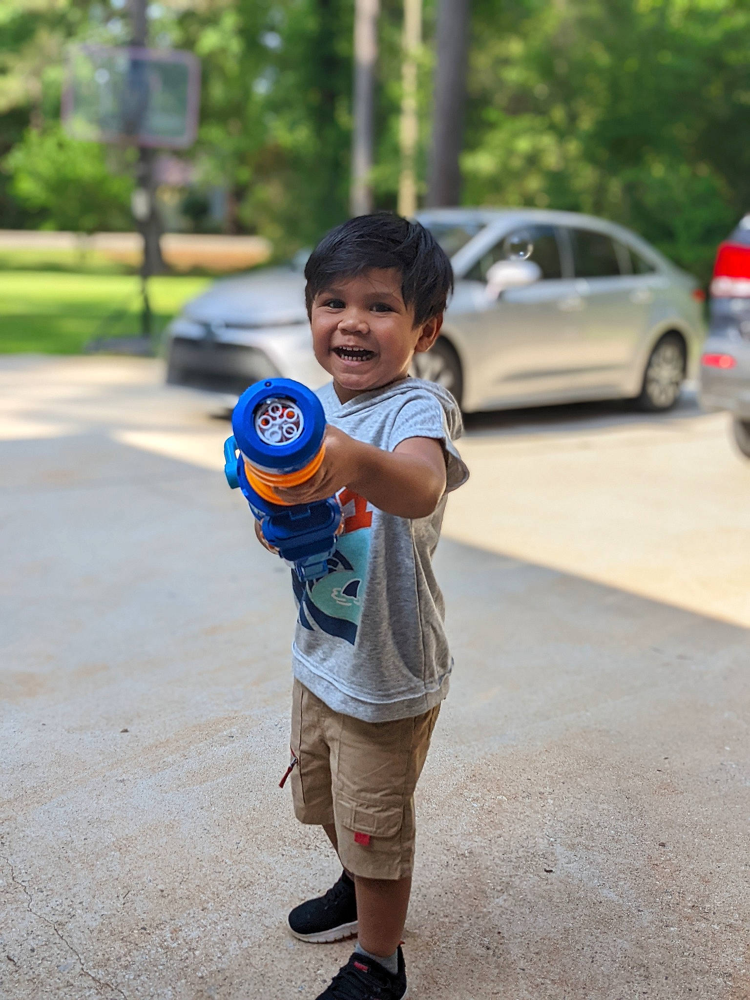 Jr is registered to the contest to win money with this photo: asphalt, car, child, family_car, happy, land_vehicle, leisure, parking, person, recreation, road, shorts, street, street_fashion, t_shirt, tire, toddler, toy, tree, vehicle