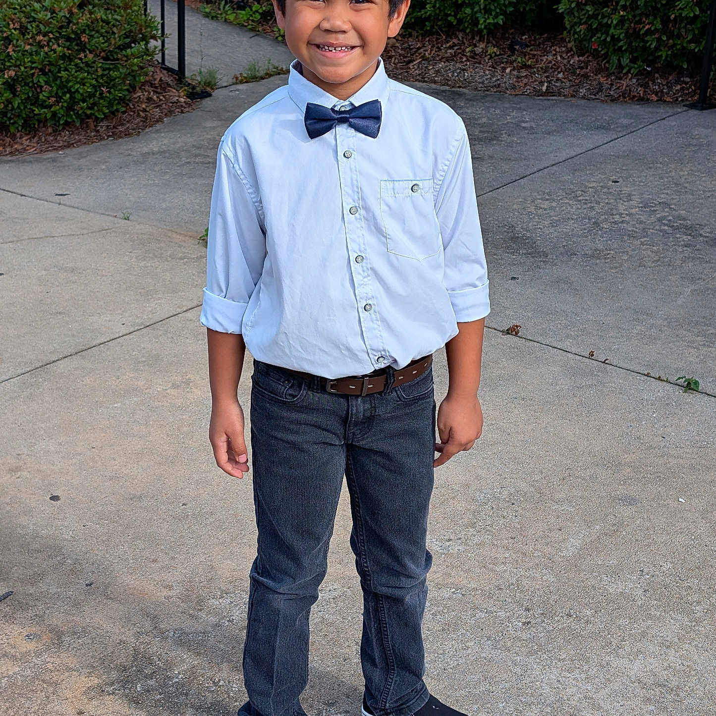 Jr joined the competition — help win amazing prizes! black_shoes, bow_tie, boy, bushes, casual, child, concrete, fashion, fence, greenery, happy, jeans, outdoor, person, portrait, sidewalk, smiling, standing, white_shirt, young