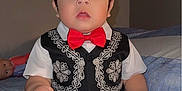 Jose Jr joined the competition — help win amazing prizes! baby, child, toddler, boy, face, clothing, bow_tie, vest, pants, socks, bed, blanket, doll, indoor, portrait, cute, expression, sitting, person, furniture