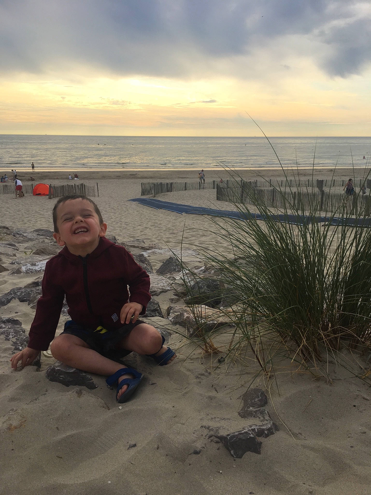 Nino participe au concours pour gagner de l'argent avec cette photo : bay, beach, cloud, coast, fun, horizon, joy, leg, mountain, ocean, person, photography, rock, sand, sea, shore, sitting, sky, tourism, vacation
