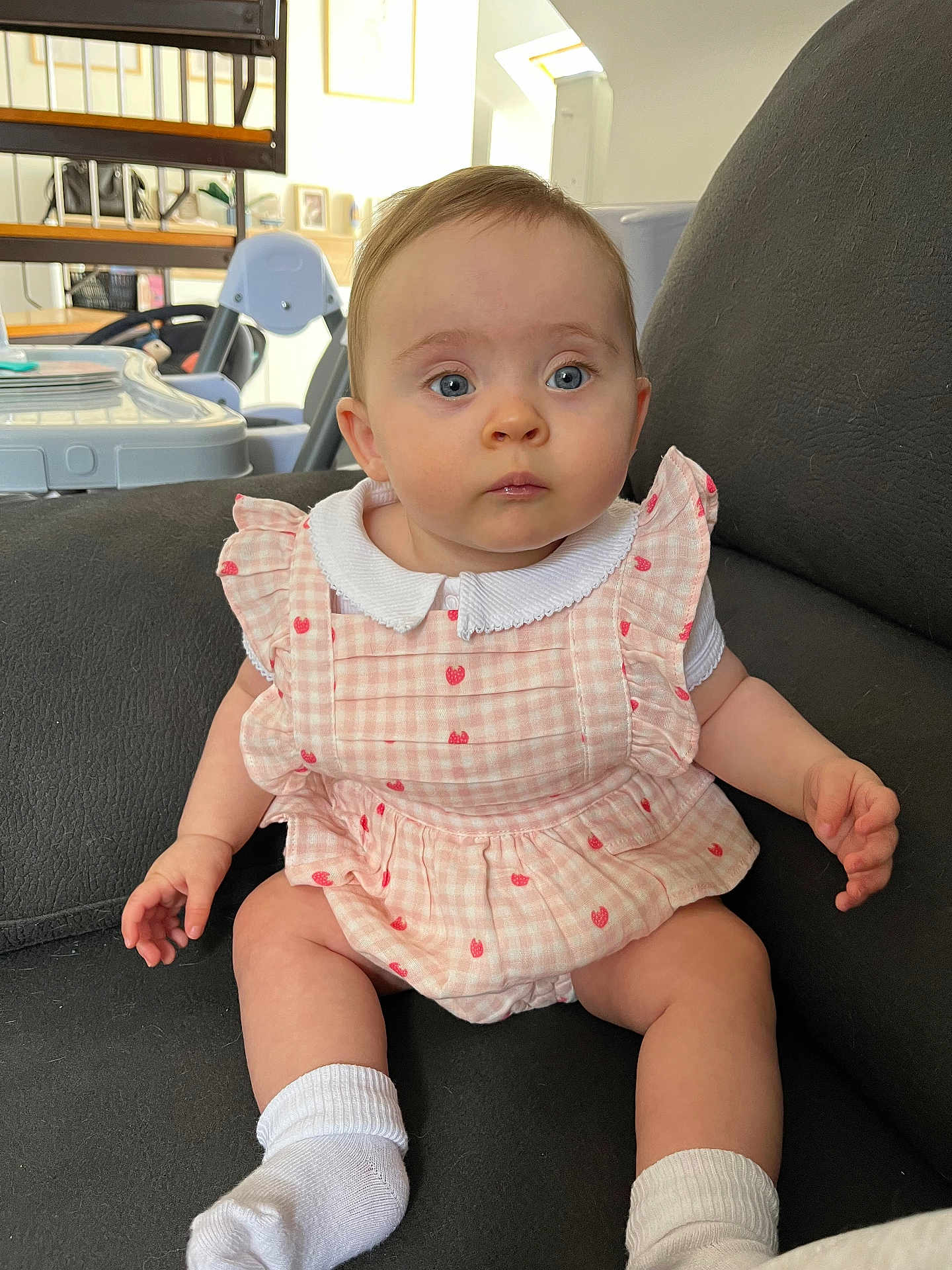 Charlie participe au concours pour gagner de l'argent avec cette photo : baby, child, infant, sitting, dress, pink, white_socks, couch, indoor, home, furniture, face, blue_eyes, curious, cute, clothing, person, young_child, soft_lighting, background_objects