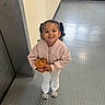 child, girl, pigtails, smiling, stuffed_animal, pink_jacket, white_pants, sneakers, indoor, floor, textured_floor, elevator, railing, happy, cute, standing, person, toy, lighting, portrait