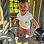 child, toddler, smiling, playground, wooden_structure, rope, outdoor, sunlight, happy, pigtails, shorts, tshirt, play, cute, person, daylight, fun, young_child, active, expression