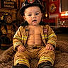 baby, child, firefighter, firefighter_hat, firefighter_jacket, fire_truck, fire_gear, boots, cute, portrait, indoor, bravery, courage, future_hero, smiling, sitting, fluffy_rug, person, young_child, costume