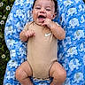baby, blue_blanket, bodysuit, clothing, cute, elephant_pattern, feet, flowers, grass, hand, happy, head, infant, lying_down, nature, outdoor, person, portrait, skin, smiling