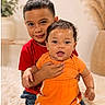 Mason joined the competition — help win amazing prizes! child, baby, sibling, indoor, portrait, smiling, red_shirt, orange_outfit, hugging, cute, family, home, rug, decor, plant, happy, toddler, seated, brother, candid
