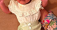 Arwa joined the competition — help win amazing prizes! baby, bow, brown_background, child, closeup, cute, floral_sleeve, hand, headband, indoors, infant, lace, lying_down, person, portrait, ribbed_pants, small_hands, soft_lighting, textured_surface, white_clothing