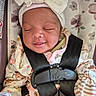 baby, bow, car_seat, child, closeup, cute, floral, headband, indoors, infant, newborn, pajamas, pattern, peaceful, resting, safety_harness, sleeping, smiling, soft_lighting, toddler