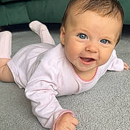 Pixie joined the competition — help win amazing prizes! baby, infant, smiling, lying_down, pink_clothing, carpet, indoor, couch, pillow, happy, cute, child, face, skin, hair, eyes, hand, footwear, home, portrait
