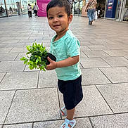 Zayan Ibne Ali is registered to the contest to win money with this photo: casual_clothing, child, daylight, footwear, happy, mickey_mouse, outdoor, people, plant, portrait, potted_plant, sandal, shirt, shopping_area, shorts, sidewalk, smile, standing, toddler, urban