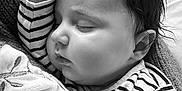 Lila-Rose participe au concours pour gagner de l'argent avec cette photo : baby, infant, sleeping, eyes_closed, striped_shirt, blanket, hand, fist, hair, cheek, ear, portrait, close_up, monochrome, black_and_white, cozy, soft_texture, couch, peaceful, nap