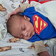 Warren participe au concours pour gagner de l'argent avec cette photo : baby, sleeping, superman_shirt, blanket, teddy_bear_pattern, infant, child, peaceful, cozy, bed, cute, portrait, rest, soft, hand, face, clothing, indoors, newborn, comfort
