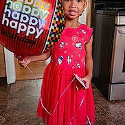 Nylah Arya joined the competition — help win amazing prizes! child, girl, birthday, balloon, red_dress, socks, indoor, kitchen, floor, smile, celebration, festive, hair_bows, standing, curtains, stove, oven, wall_switch, happy, person