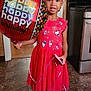 child, girl, birthday, balloon, red_dress, socks, indoor, kitchen, floor, smile, celebration, festive, hair_bows, standing, curtains, stove, oven, wall_switch, happy, person