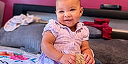 Nylah Arya joined the competition — help win amazing prizes! baby, bed, blanket, child, clothing, cute, decor, happy, home, indoor, infant, jeans, person, portrait, purple_shirt, sitting, smiling, socks, tapestry, wooden_sign