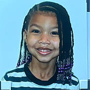 Nylah Arya is registered to the contest to win money with this photo: child, smiling, portrait, braids, beads, striped_shirt, happy, face, young, person, hair, indoors, light_blue_background, cute, close_up, joy, fashion, casual, girl, headshot