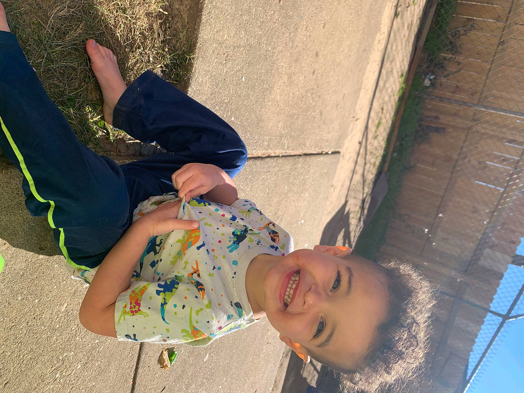 Keaton is registered to the contest to win money with this photo: child, electric_blue, eyewear, foot, fun, grass, happy, human_body, human_leg, joy, leaf, leg, leisure, people, person, shadow, sitting, smile, thigh, toddler
