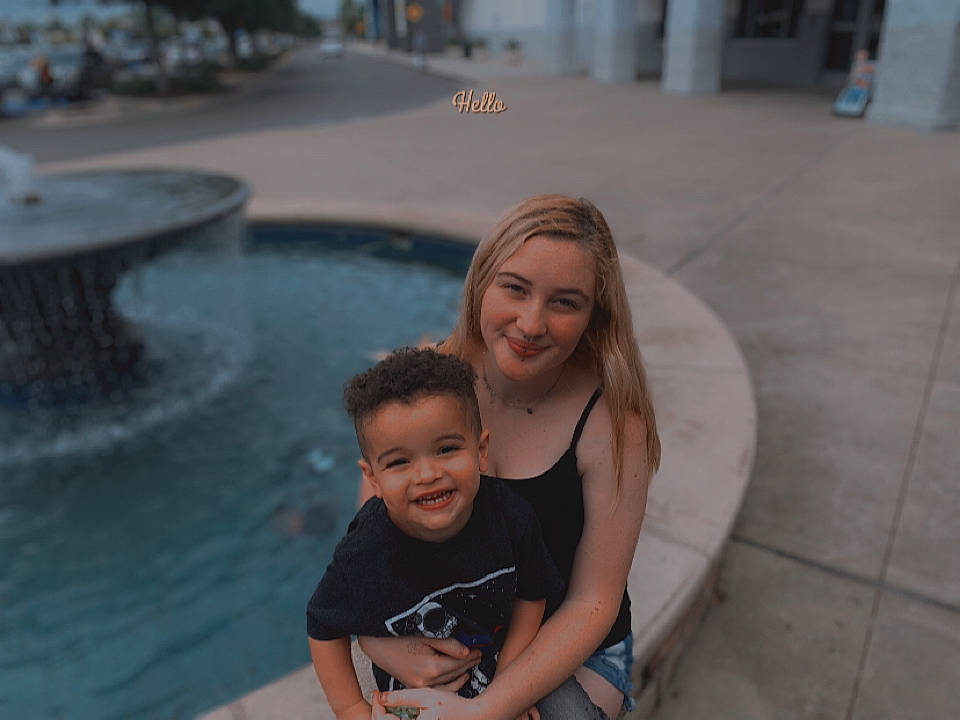 Keaton is registered to the contest to win money with this photo: asphalt, beauty, flooring, fun, happy, human, joy, leisure, person, photograph, public_space, recreation, road_surface, sitting, smile, snapshot, summer, swimming_pool, t_shirt, toddler