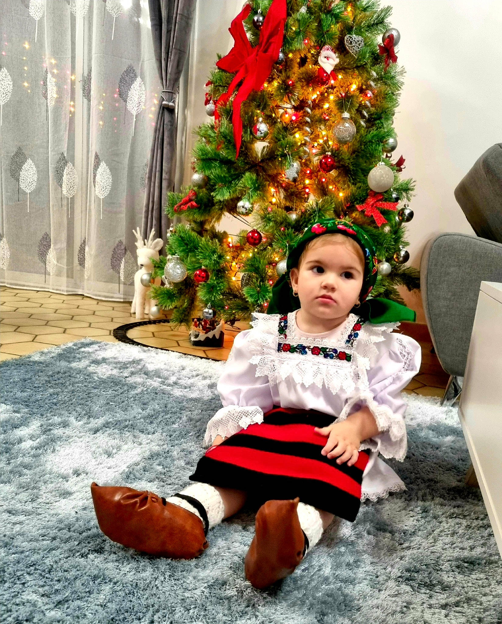 Andreea a rejoint le concours — aidez-le/la à gagner de superbes lots ! christmas, christmas_decoration, christmas_eve, christmas_ornament, christmas_tree, conifer, event, fictional_character, happy, hat, headwear, holiday, holiday_ornament, lap, ornament, person, plant, sitting, toddler, tradition