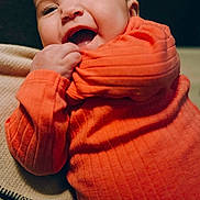Maggie is registered to the contest to win money with this photo: baby, child, orange_clothing, smiling, happy, cute, portrait, infant, sleeve, grip, blanket, cozy, closeup, face, skin, eyelashes, mouth, indoor, person, joyful