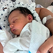 Aryanna Lott joined the competition — help win amazing prizes! newborn, baby, sleeping, infant, portrait, hospital, blanket, swaddled, white_clothing, face, closed_eyes, peaceful, adult_hand, caregiving, medical_setting, patterned_fabric, close_up, indoors, family, tender