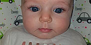 Emeline a rejoint le concours — aidez-le/la à gagner de superbes lots ! baby, baby_girl, blue_eyes, car_pattern, child, closeup, clothing, curly_hair, cute, expressionless, face, indoors, infant, patterned_background, portrait, shirt, skin, soft_light, text, young