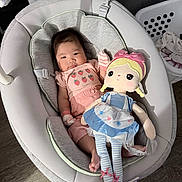 Alyana Kate is registered to the contest to win money with this photo: baby, infant, child, doll, plush_toy, rocker, baby_seat, pink_clothing, dress, bow, strawberries, sitting, lying_down, indoors, nursery, laundry_basket, wood_floor, curtain, portrait, smiling
