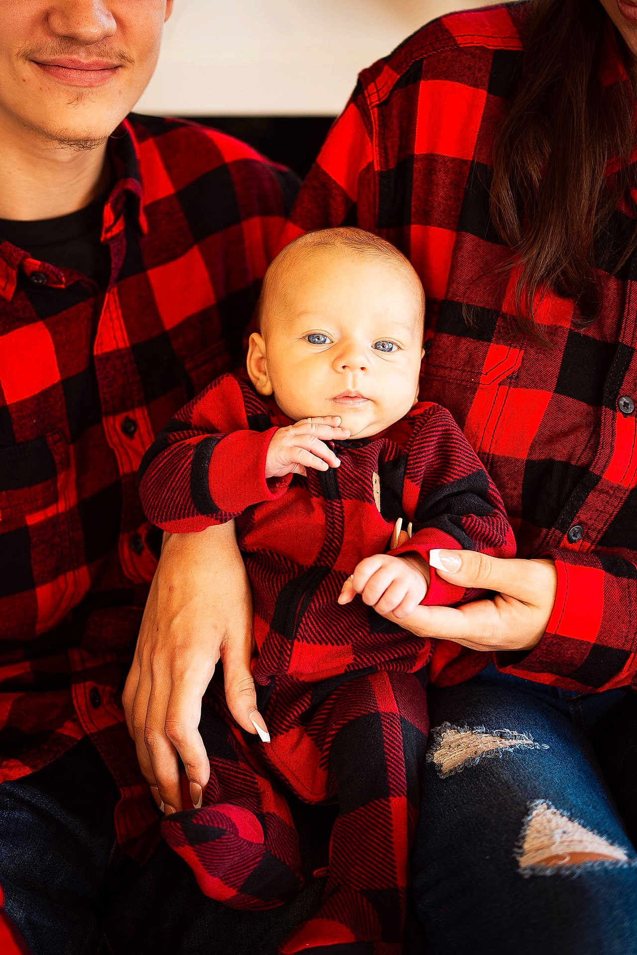 Evren is registered to the contest to win money with this photo: baby, child, infant, family, plaid, red_and_black, matching_outfits, hands, jeans, ripped_jeans, person, casual_clothing, indoor, portrait, smiling, closeup, holding, cozy, cute, warm