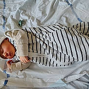 Thélyo participe au concours pour gagner de l'argent avec cette photo : baby, sleeping, bed, striped_swaddle, hat, pacifier, hand, blanket, infant, cute, resting, cozy, indoors, child, newborn, face, clothing, soft, peaceful, toddler