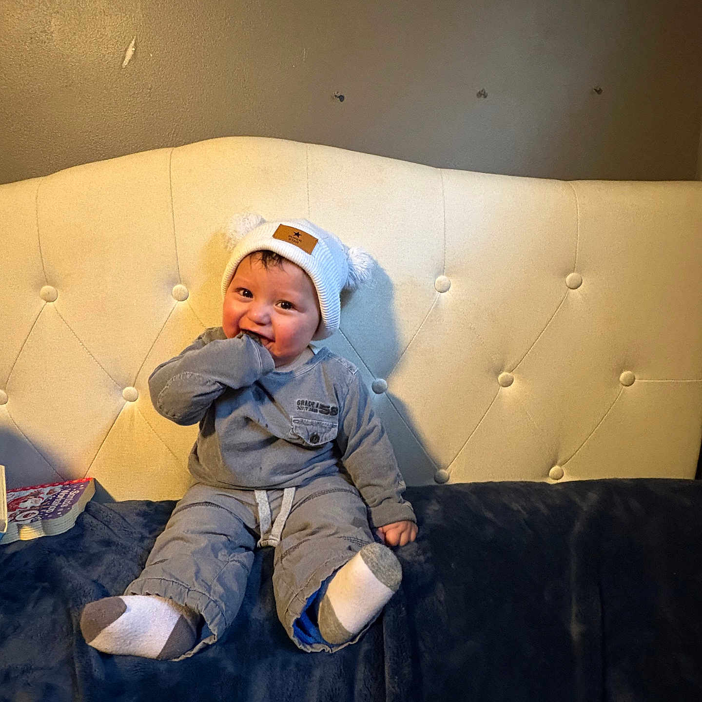 Alexander is registered to the contest to win money with this photo: baby, baseballcap, clothing, coat, couch, face, footwear, furniture, happy, hat, head, hosiery, jacket, pants, person, photography, portrait, shoe, sitting, sock